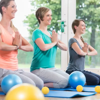 Young women doing  yoga during postnatal recovery lesson